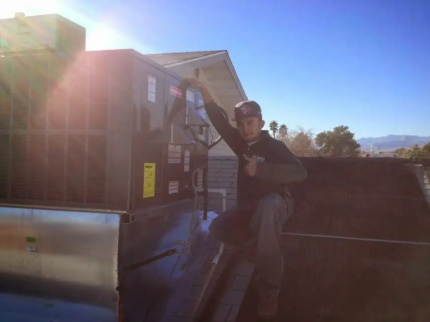 HVAC technician performing Heat Pump Repair on a rooftop unit in Mayville